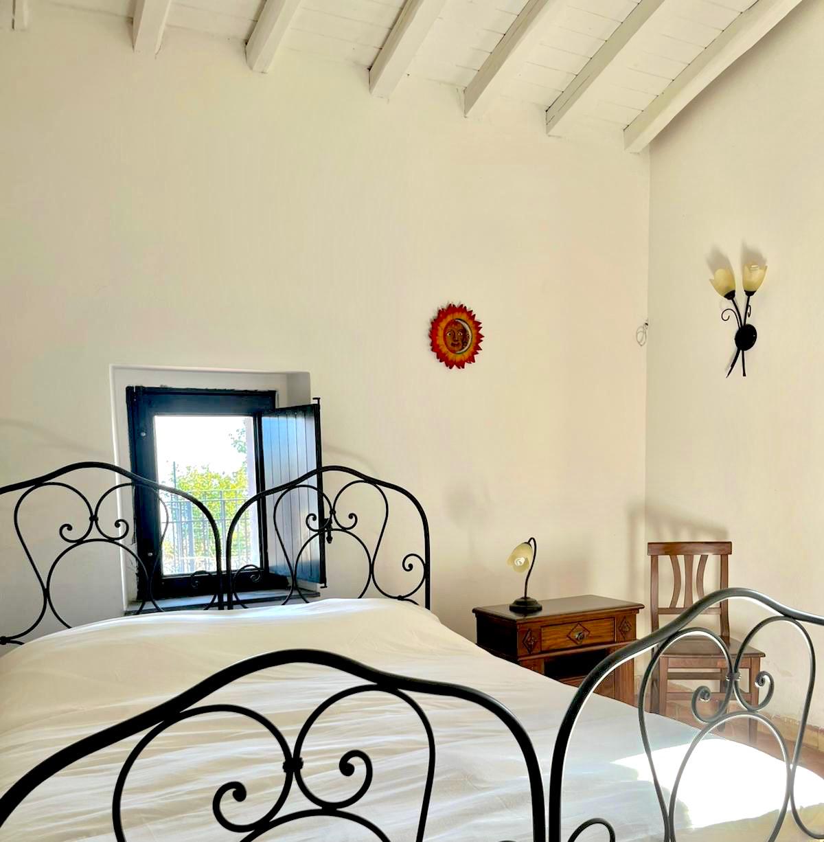 Camera luminosa con letto in ferro battuto e affaccio — Etna 1928 Country House